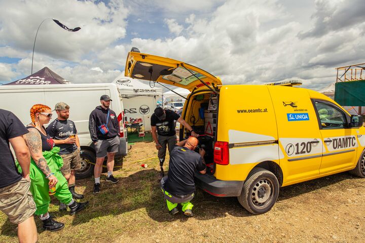 Pannenhilfe auf dem Festivalgelände mit Festivalgästen im offenen Pannenauto