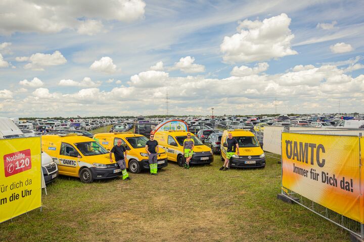 Gruppenfoto mit ÖAMTC Pannenautos mit Pannenfahrer auf dem Nova Rock vor dem Festival Parkplatz
