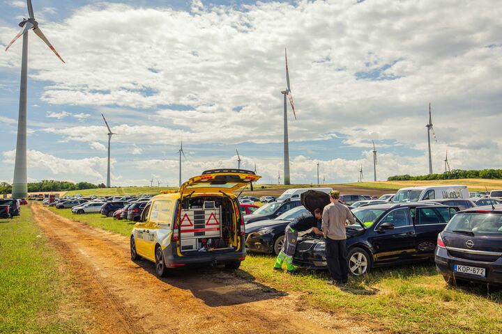 ÖAMTC Pannenhelfer hilft mit gelbem Pannenauto bei einer Panne auf dem Parkplatz vom Festival Nova Rock. 