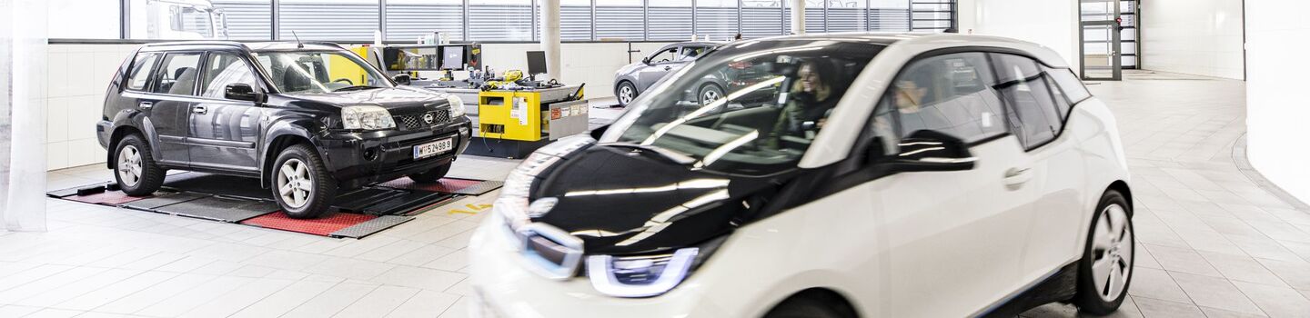 Ein kleines weißes Elektrofahrzeug in einer Prüfhalle