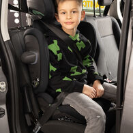 OEAMTC-Kindersitztest-Fruehjahr-2025 (8) Ein Junge sitzt im Rahmen des Kindersitztests in einem Kindersitz auf der Rückbank eines Autos. Er trägt einen grün-schwarzen Pullover und eine graue Jeanshose.