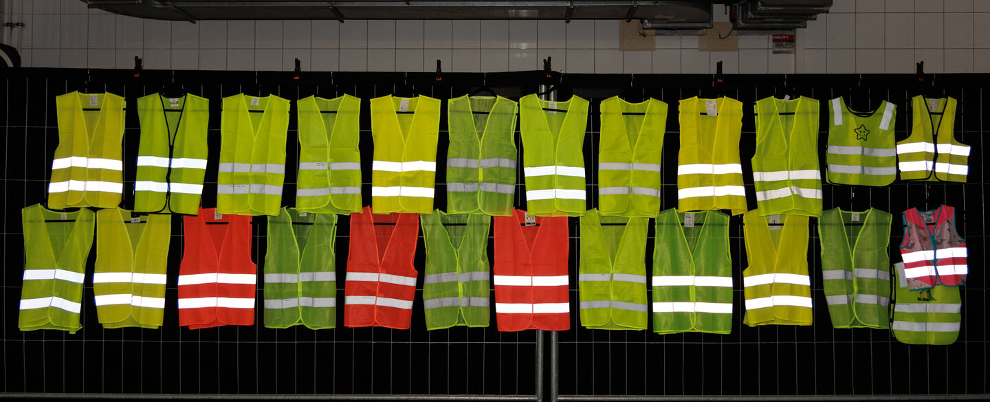 OEAMTC-Warnwesten-Test-2025 In einer Testhalle hängen 25 Warnwesten an der Wand.