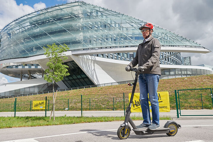 Mann fährt auf E-Scooter.