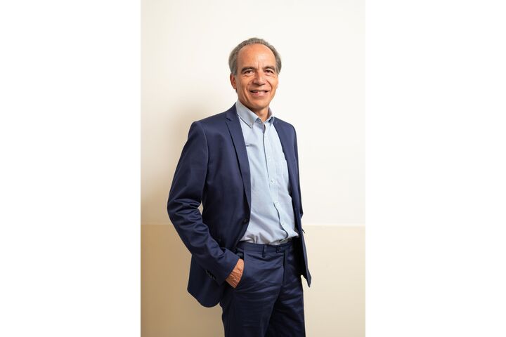 Lächelnder Präsident Günter Thumser im Anzug vor einer Wand