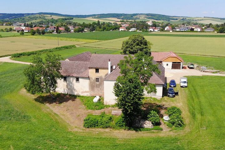 Gebäude der Mühle in Breitenwaida bei Hollabrunn, die Urlaubs-, Therapie- und Beratungszentrum sind, eingebettet in grüner, hügeliger Landschaft.