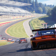 Screenshot aus Rennsport. Man sieht GT3 Fahrzeuge von hinten.