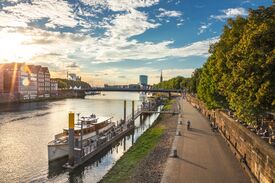 Promenade an der Weser mit Blick auf ein Schiff und Bäume