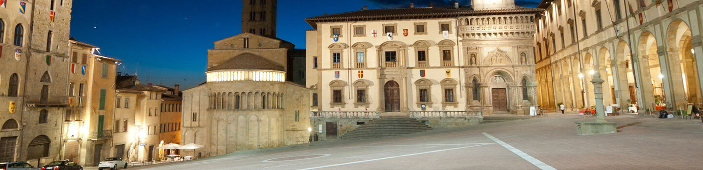 Ein Blick auf die Straßen von Arezzo bei Nacht, mit den sanft erleuchteten Gebäuden und den ruhigen Gassen, die eine zeitlose Atmosphäre schaffen.