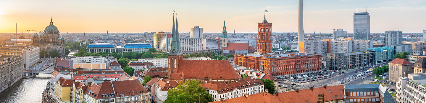  Ruhige Abendstimmung über den Dächern von Berlin, mit Blick auf die Spree und den Umrissen der Gebäude, die im sanften Licht des Sonnenuntergangs erstrahlen.