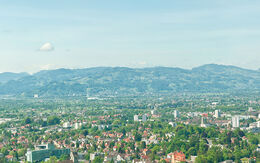 Mit Blick auf Bregenz entfaltet sich ein beeindruckendes Panorama, in dem die Stadt von den saftig grünen Berglandschaften des Sommers eingerahmt wird.