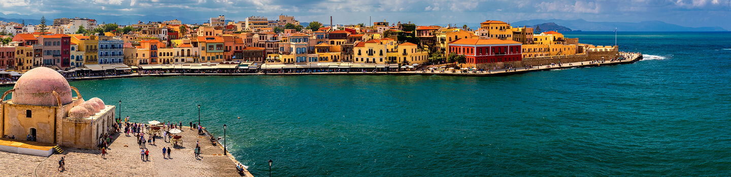 Die bunten Häuser des alten Hafens von Chania säumen das ruhige Wasser und erzeugen eine malerische und einladende Atmosphäre
