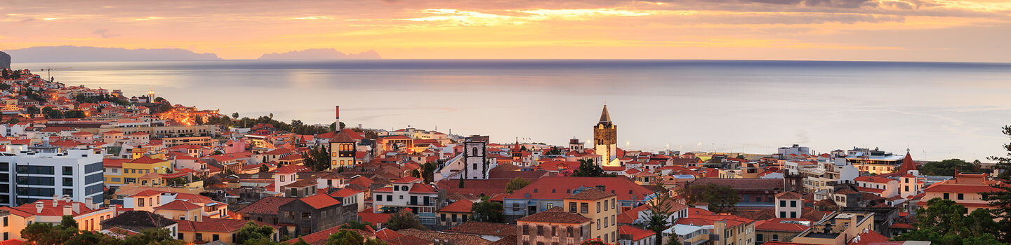 Funchal, die Hauptstadt von Madeira, bietet eine beeindruckende Aussicht, mit seiner bunten Architektur, die sich terrassenförmig den Hang hinunter bis zum glitzernden Meer erstreckt.