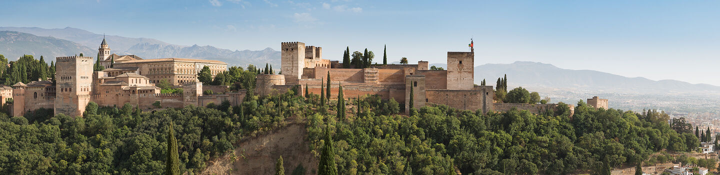 Die Alhambra in Granada thront majestätisch über der Stadt und präsentiert sich mit ihrer eindrucksvollen Architektur und hellen Fassaden als eines der bemerkenswertesten Wahrzeichen Spaniens.