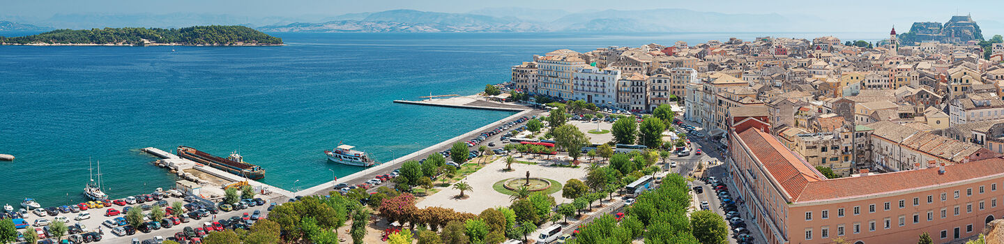 Von oben betrachtet, entfaltet die Stadt Kerkira ein beeindruckendes Panorama, mit seinen charmanten Gebäuden, die zum funkelnden Meer hin abfallen.