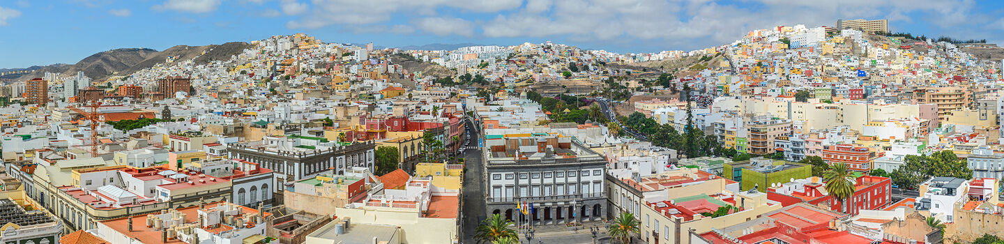 Das Stadtpanorama von Las Palmas zeigt eine dichte Ansammlung von Gebäuden, deren Farbpalette sanfte Farben widerspiegelt und der Stadt einen warmen und lebendigen Charakter verleiht.