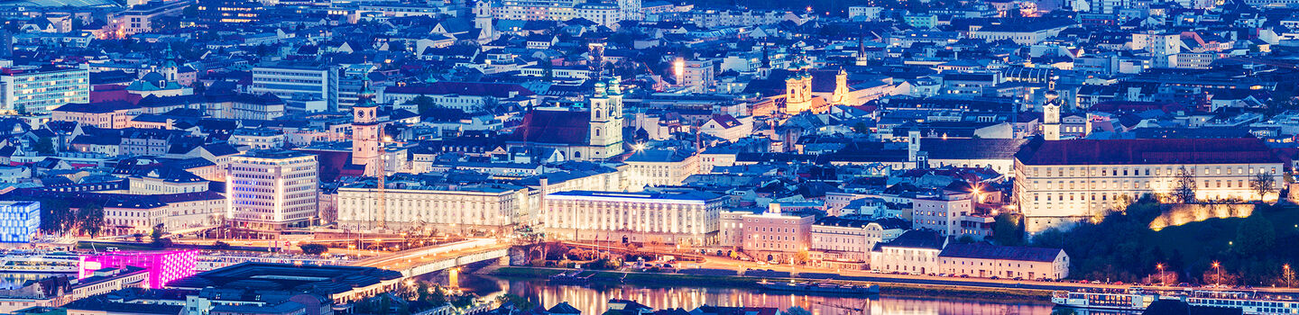 Von oben betrachtet wird Linz bei Nacht zu einem schillernden Lichtermeer, das seine historischen und modernen Facetten eindrucksvoll beleuchtet.
