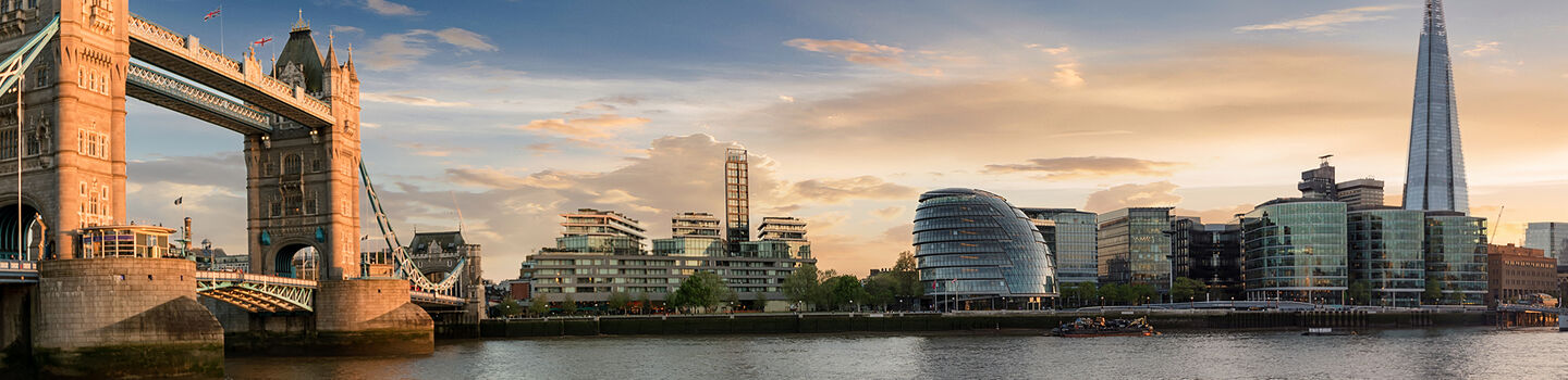 Im sanften Abendlicht erhebt sich die Tower Bridge majestätisch gegen die funkelnde Skyline der Stadt London.