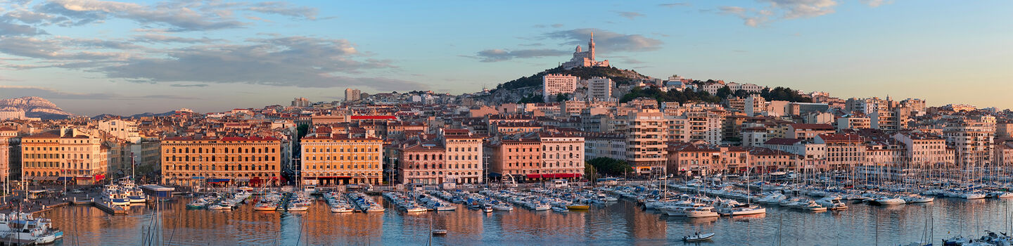 Panoramablick auf den Vieux-Port von Marseille mit Segelbooten und der Basilika Notre-Dame de la Garde im Hintergrund