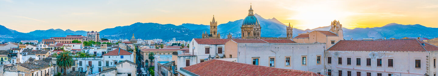 Blick auf Palermo Palermo bei Sonnenuntergang, mit den historischen Gebäuden und den kühlen, blauen und grauen Tönen des Himmels, die die Stadt umhüllen.