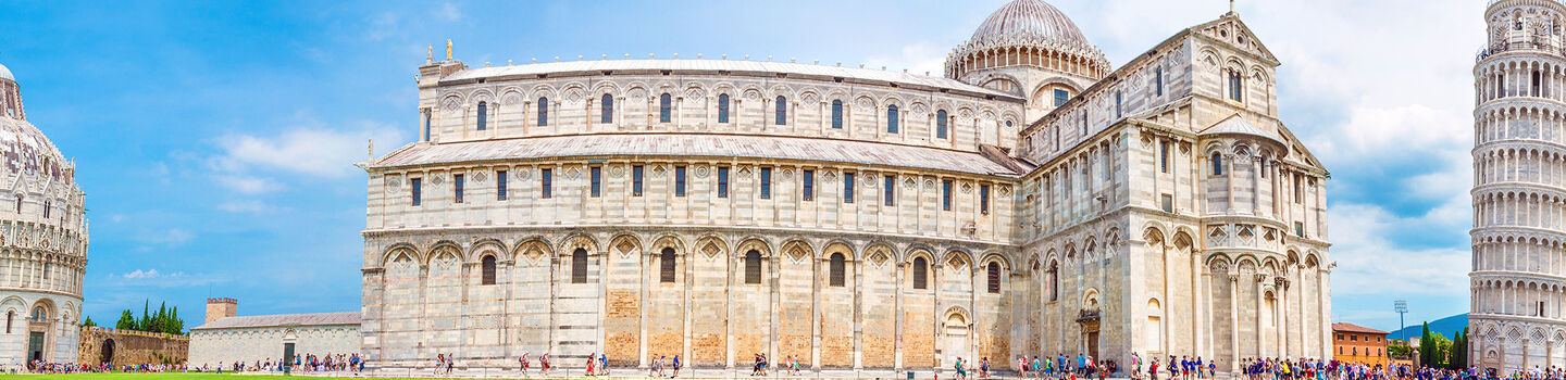 Ein beeindruckendes Panorama vom Piazza dei Miracoli in Pisa, mit dem berühmten Schiefen Turm und den umliegenden historischen Gebäuden, die die weite, offene Fläche dominieren.