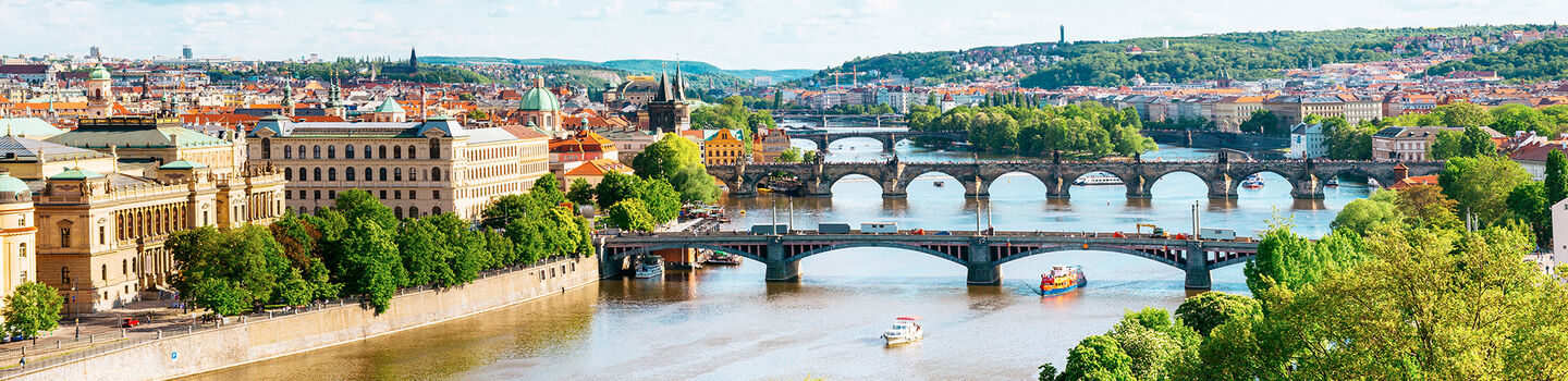 Geschwungen über die träge, glänzende Moldau erstrecken sich die historischen Brücken von Prag, eingerahmt von den prächtigen Gebäuden der Stadt.