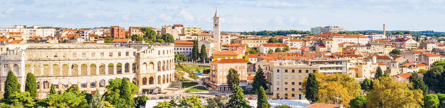 Blick auf das Amphitheater von Pula, mit den antiken Steinen, die im warmen Licht der Sonne strahlen.