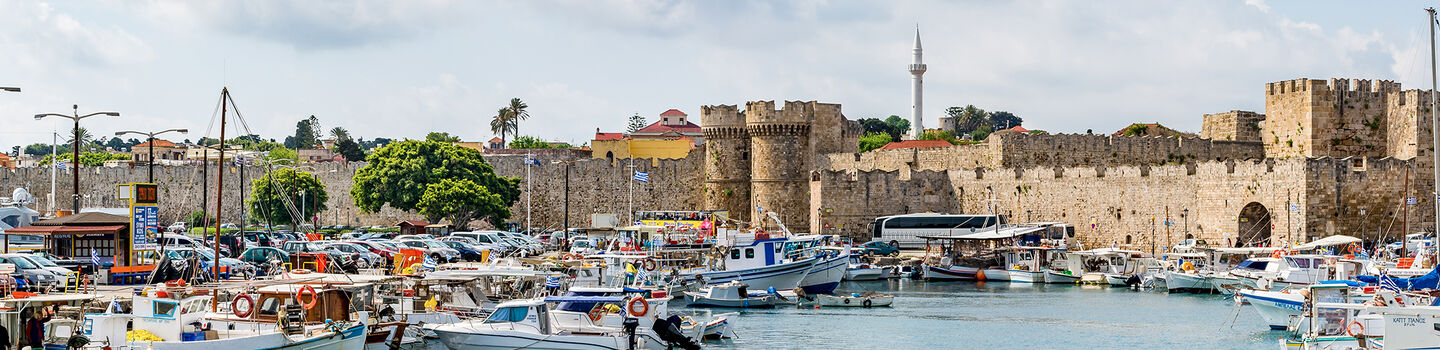 Der idyllische Fischerhafen von Rhodos Stadt liegt malerisch am Fuße der beeindruckenden Stadtmauer.