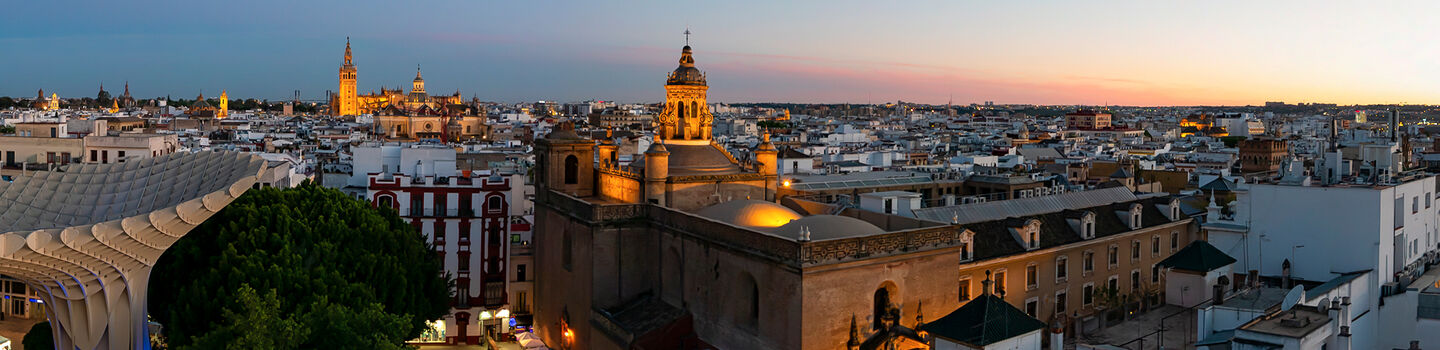 Mit dem Einsetzen des Sonnenuntergangs wirft das letzte Tageslicht sanfte Schatten über die Altstadt von Sevilla und lässt die historischen Gebäude in einem subtilen Glanz erstrahlen.