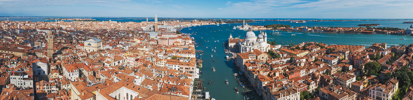Ein beeindruckender Blick von oben auf Venedig, mit den charakteristischen Dächern und den verwinkelten Kanälen, die sich durch die Stadt ziehen.
