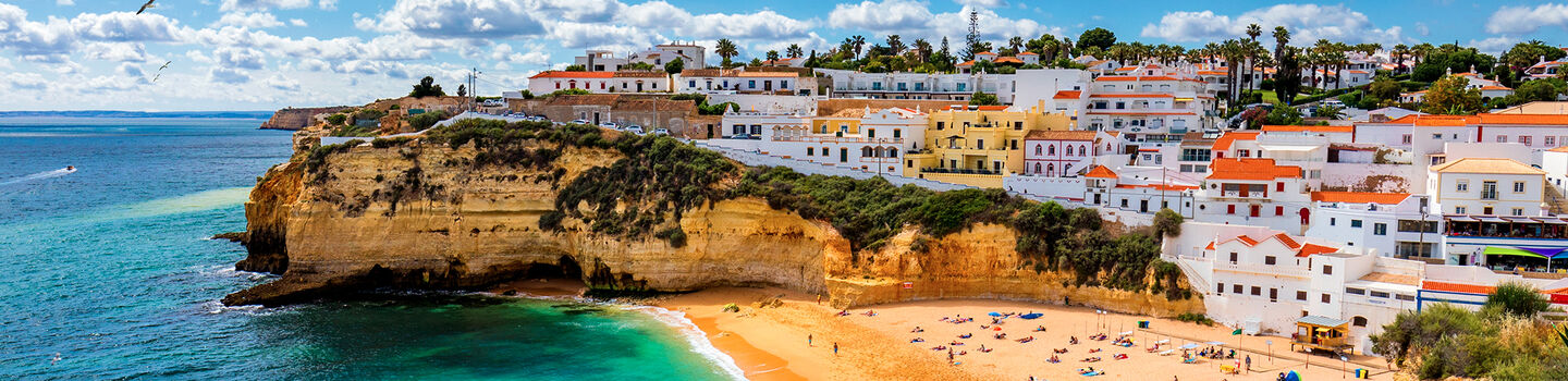 Das malerische Fischerdorf Carvoeiro an der Algarve erstreckt sich entlang der zerklüfteten Küste, wo traditionelle weiße Häuser den Blick zum türkisblauen Meer lenken.