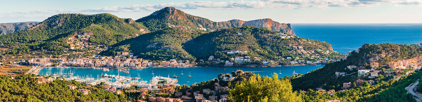 Aus der Ferne bietet der Hafen von Port de Andratx auf Mallorca, umgeben von den sanften, grünen Hügeln, einen malerischen und beruhigenden Anblick.