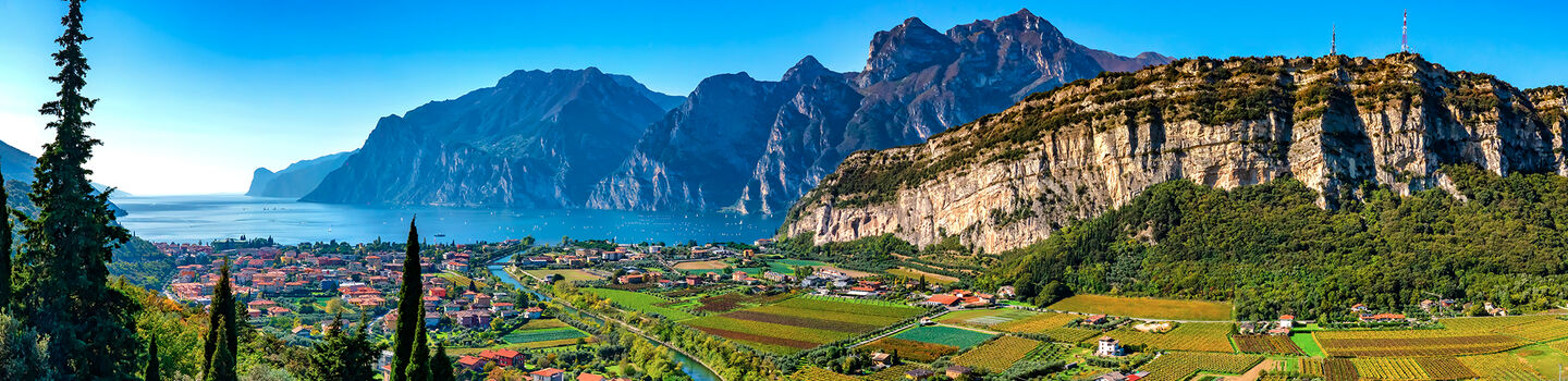Eine schöne Luftaufnahme zeigt die beeindruckenden Berge rund um Torbole am Gardasee, die sich majestätisch im klaren Tageslicht erheben.