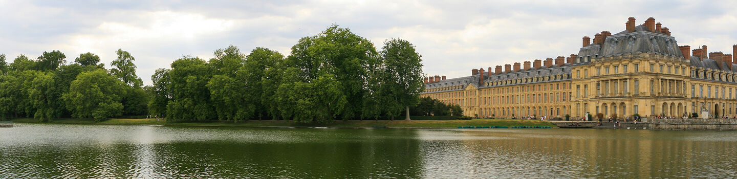 Panoramablick auf das Schloss Fontainebleau mit dem imposanten Étang aux Carpes im Vordergrund
