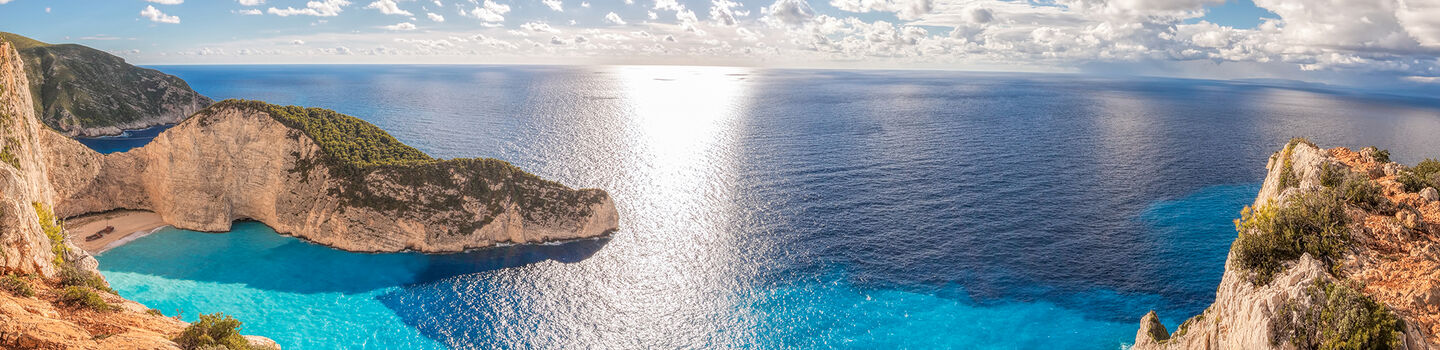 Von oben betrachtet, erscheint Navagio Beach auf Zakynthos umgeben von dramatischen Klippen, die sich steil in das türkisblaue Meer hinunter erstrecken.