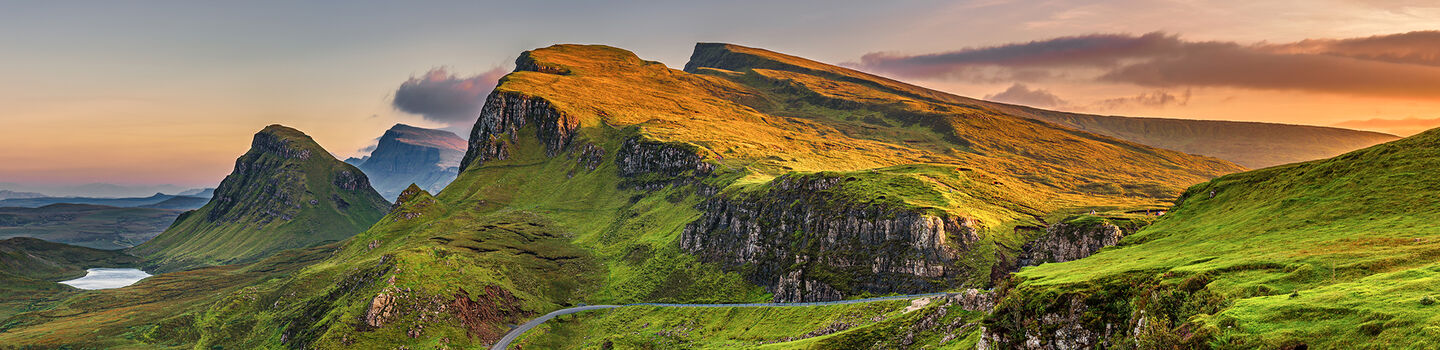 Die Quiraing Berge auf der Isle of Skye erstrahlen im sanften Licht des Sonnenuntergangs, das die raue Schönheit der schottischen Landschaft hervorhebt.