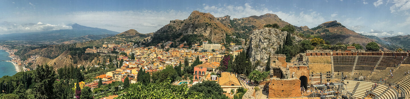 Ein eindrucksvoller Blick auf das antike Theater von Taormina, mit den majestätischen Bergen im Hintergrund.