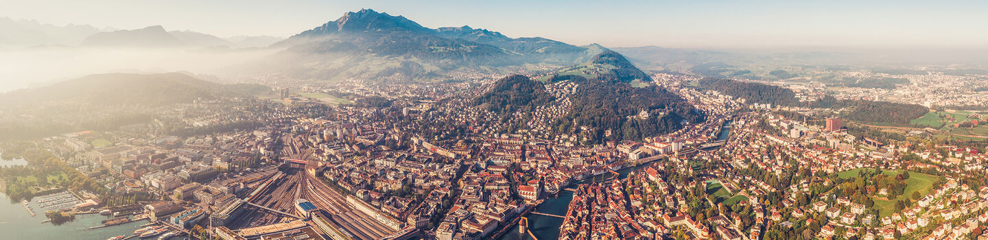 Aus der Vogelperspektive bietet Luzern einen wunderschönen Panoramablick, der den See, die dicht bebaute Stadt mit ihren Straßen und die umgebenden grünen Hügel einschließt.