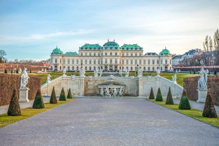 Das Schloss Belvedere in Wien mit seiner prächtigen barocken Architektur und den gepflegten Gärten im Vordergrund.