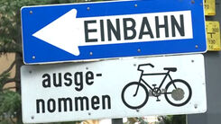 Hinweiszeichen Einbahnstraße mit der Zusatztafel ausgenommen für Radfahrer. 