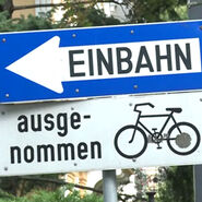 Hinweiszeichen Einbahnstraße mit der Zusatztafel ausgenommen für Radfahrer. 