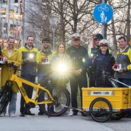 Die Verantwortlichen der Radlichtaktion haben sich alle für ein Gruppenfoto versammelt und leuchten mit einem vorschriftsgemäßen Radlicht in die Kamera