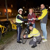 Gemeinsam mit der Polizei informieren ÖAMTC-Techniker eine Radfahrerin mit Infomaterial und tauschen ihr Licht aus.