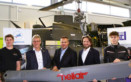 Von links nach rechts: Ein Schüler der HTBLA Eisenstadt, Martin Weger (Technical Director, HeliAir), Thomas Schober (Direktor HTBLA Eisenstadt), Marco Trefanitz (GF ÖAMTC-Flugrettung) und ein weiterer Schüler stehen vor einem geöffneten Hubschrauber in Wartung und halten ein Rotorblatt gemeinsam in der Hand.