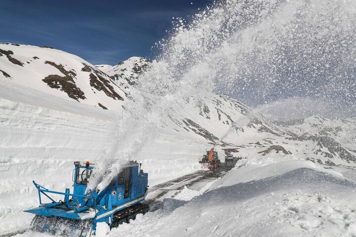 Schneepflug räumt Schnee von einer Straße.