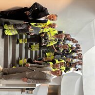 ÖAMTC-Direktor Oliver Schmerold steht zusammen mit allen Pannenfahrern, die teilgenommen haben. Einer der Sieger, Jordan Simeonovic, hält die Trophäe.