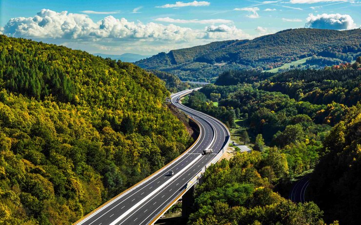 Auf dem Foto ist der Autobahnabschnitt der D2 zwischen den Städten Kriváň und Mýtna zu sehen. Das Foto zeigt die Autobahn, die auf beiden Seiten von grünen Wäldern umrandet.wird.