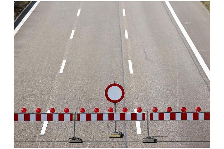 Drei Fahrstreifen einer Autobahn mit einer Absperrung und einem "gesperrt" Verkehrszeichen.