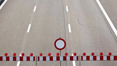 Drei Fahrstreifen einer Autobahn mit einer Absperrung und einem "gesperrt" Verkehrszeichen.