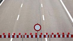 Drei Fahrstreifen einer Autobahn mit einer Absperrung und einem "gesperrt" Verkehrszeichen.