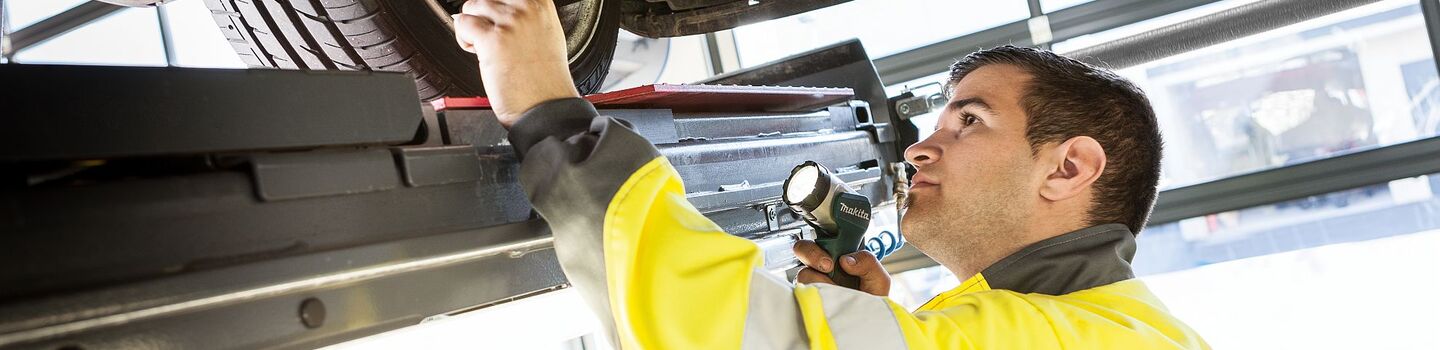 Prüfung eines Autos auf der Hebebühne durch einen ÖAMTC Kfz-Techniker.